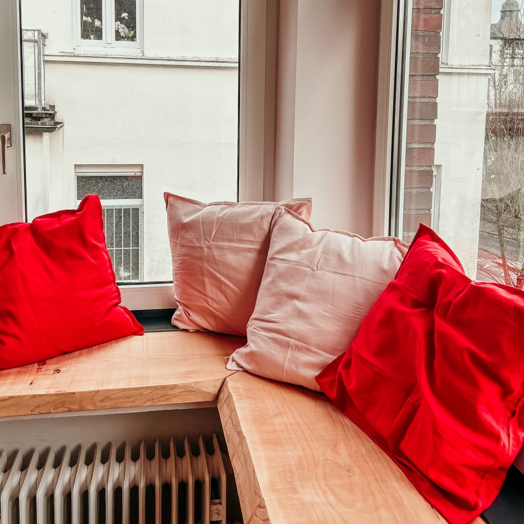 gemütliche Sitzecke mit rosafarbenen und roten kissen