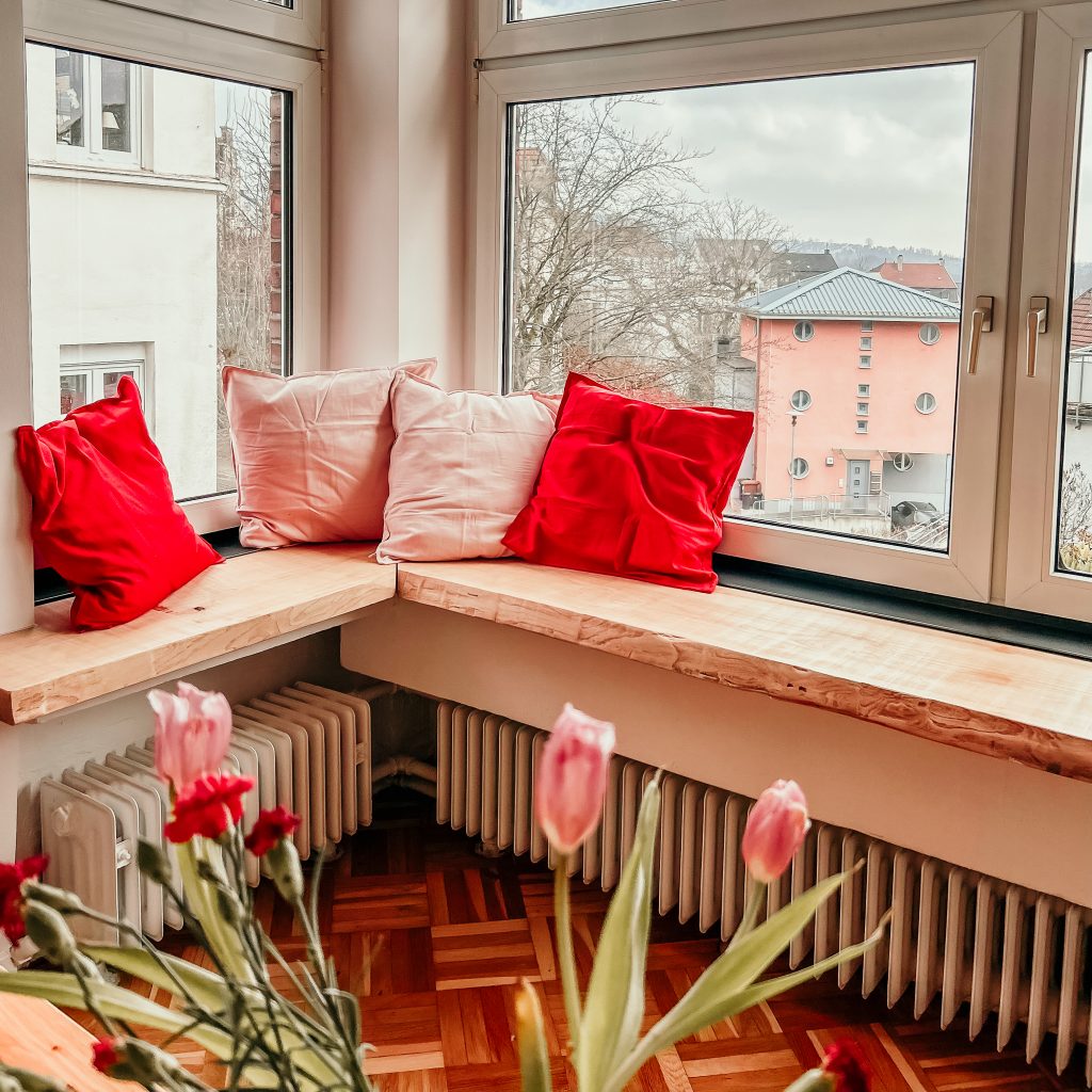 gemütliche Sitzecke mit rosafarbenen und roten kissen